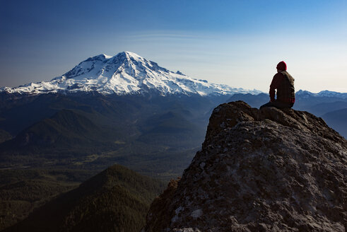 Männlicher Wanderer sitzt auf einem Berg im Mount Rainier National Park - CAVF30128