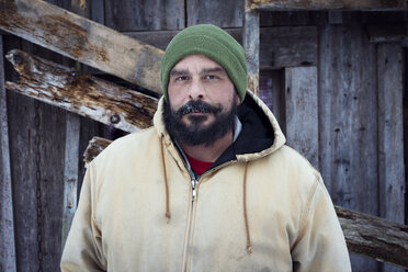 Portrait of confident man standing against cottage - CAVF30173