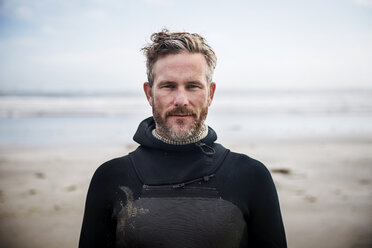 Porträt eines selbstbewussten Surfers am Strand - CAVF30261