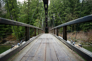 Wooden bridge over Snoqualmie River against trees - CAVF30268