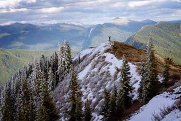 Hiker standing on cliff against cloudy sky - CAVF30270