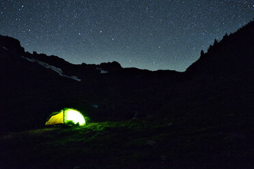 Beleuchtetes Zelt auf dem Silhouettenberg bei Nacht - CAVF30284