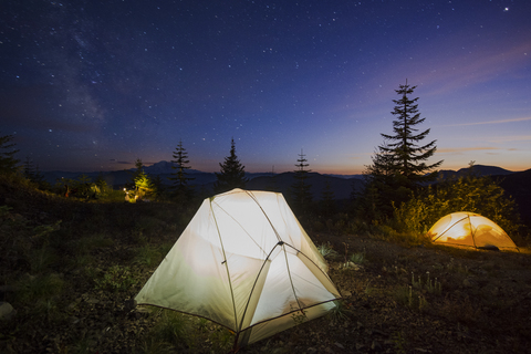 Illuminated tents against on field star field stock photo