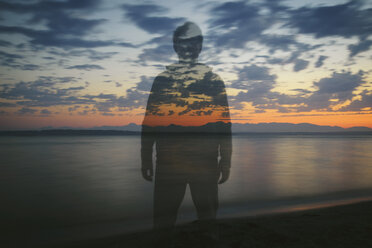 Doppelbelichtung eines am Strand stehenden Mannes gegen den bewölkten Himmel bei Sonnenuntergang - CAVF30375