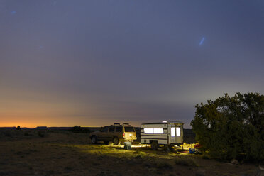 Car and travel trailer on field during sunset - CAVF30385