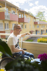 Mann im Rollstuhl auf dem Balkon - FOLF02300