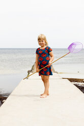 Girl standing on jetty with fishing net - FOLF02323