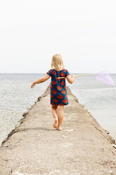 Rear view of girl holding fishing net - FOLF02324