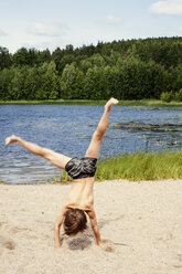 Junge macht Wagenrad am Strand - FOLF02337