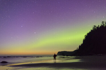Silhouette hiker standing at Olympic Coast against star field during dusk - CAVF30396