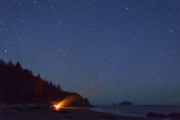 Lagerfeuer an der Olympia-Küste gegen das Sternenfeld bei Nacht - CAVF30397