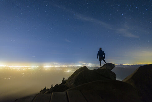 Silhouette Mann stehend auf Felsen gegen Sternenfeld am Mount Pilchuck State Park während der Nacht - CAVF30409