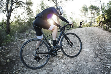 Seitenansicht eines Mannes beim Radfahren auf einem unbefestigten Weg - CAVF30457