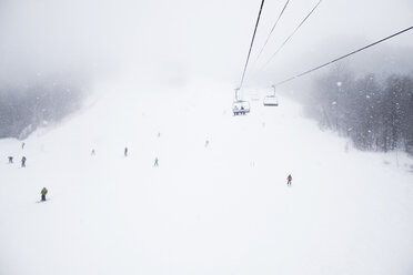 Low angle view of ski lift over snow covered field - CAVF30534