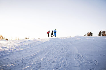 Freunde genießen auf schneebedeckten Berg gegen klaren Himmel - CAVF30545