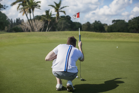 Rückansicht eines Mannes, der sich auf einen Golfplatz konzentriert, lizenzfreies Stockfoto