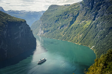 Ein Schiff fährt im Geirangerfjord an Bergen vorbei - FOLF02421