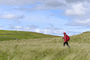 Senior woman hiking in grassland - FOLF02539