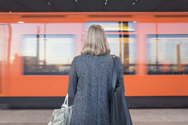 Rückansicht einer Frau, die in der Metro von Helsinki steht - FOLF02565