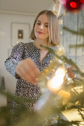 Junge Frau beim Schmücken des Weihnachtsbaums - FOLF02566