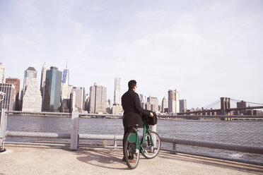 Businessman with bicycle enjoying city view from observation point - CAVF30570