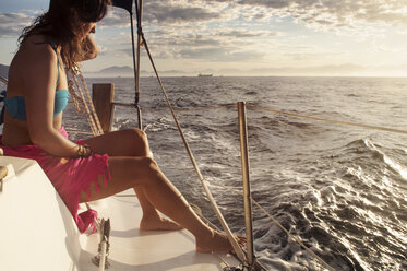 Seitenansicht einer Frau, die in einem Boot auf dem Meer gegen den Himmel bei Sonnenuntergang sitzt - CAVF30584