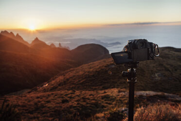 Videokamera auf einem Stativ auf einem Berg bei Sonnenuntergang - CAVF30624