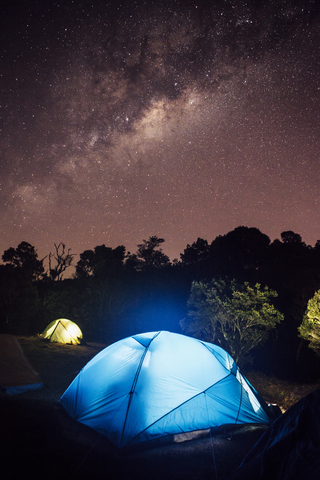 Beleuchtetes Zelt auf dem Feld bei Nacht, lizenzfreies Stockfoto