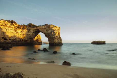 Scenic view of natural arch in sea at Algarve against clear sky stock photo