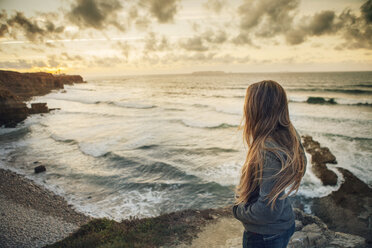 Seitenansicht einer am Strand stehenden Frau bei Sonnenuntergang - CAVF30683