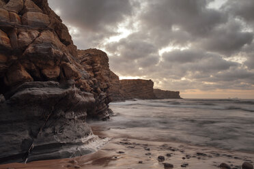 Scenic view of sea by rock formation against cloudy sky - CAVF30684