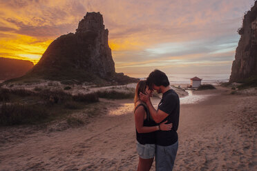 Seitenansicht eines romantischen Paares am Strand bei Sonnenuntergang - CAVF30696