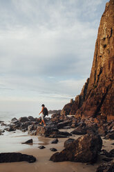 Mann geht auf Felsen am Ufer gegen den Himmel - CAVF30702