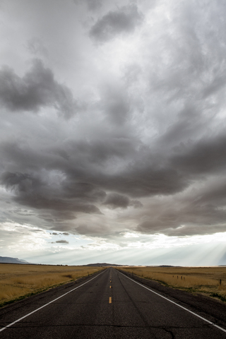 Landschaftlicher Blick auf Gewitterwolken über einer Landstraße, lizenzfreies Stockfoto