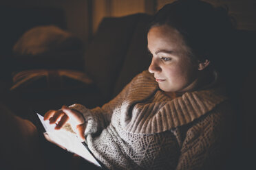 Frau mit Tablet-Computer beim Entspannen auf dem Sofa zu Hause - CAVF30820