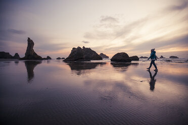 Full length of woman walking at Bandon beach against sky during sunset - CAVF30822