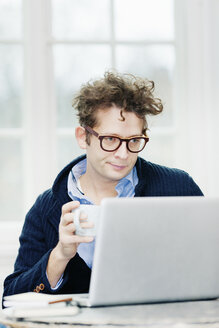 Man using laptop and drinking coffee - FOLF02628