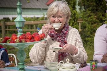 Woman having cup of tea outdoors - FOLF02781