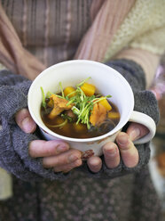 Woman holding mug with mushroom soup - FOLF02825