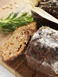 Karottenbrot mit Rosmarin auf dem Schneidebrett - FOLF02860