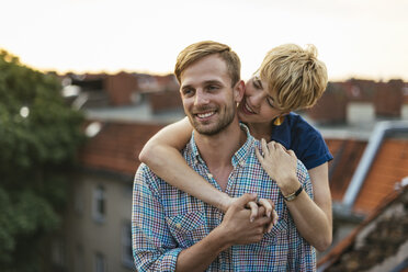 Young couple hugging on rooftop at sunset - FOLF02904