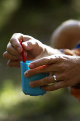 Nahaufnahme eines Mannes, der einen Plastikbecher hält - FOLF02916