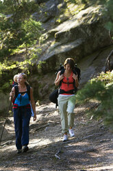 Two women hiking in forest with baby boy - FOLF02920