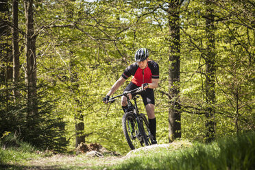 Älterer Mann fährt mit dem Mountainbike durch den Wald - FOLF02938