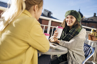 Zwei junge Frauen sitzen mit Kaffee im Freien - FOLF03307