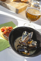 Muschelsuppe, Brushetta und Bierglas auf Holztisch - FOLF03338