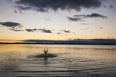 Silhouette eines im See schwimmenden Mannes - FOLF03384
