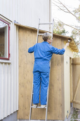 Mature woman painting shed - FOLF03431