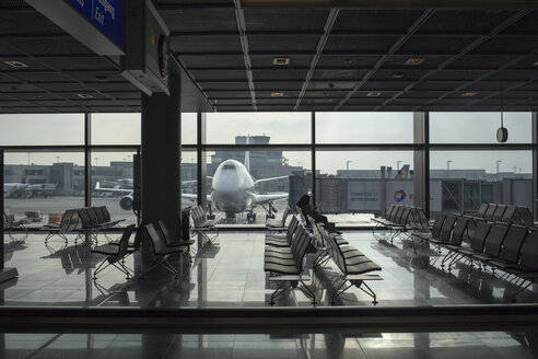 Flughafenterminal mit Flugzeug im Hintergrund - FOLF03604