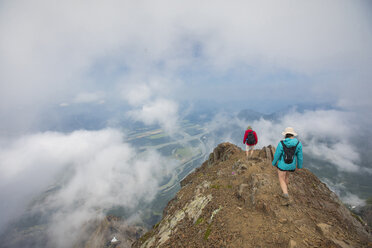 High angle view of friends hiking on mountain amidst clouds - CAVF30908